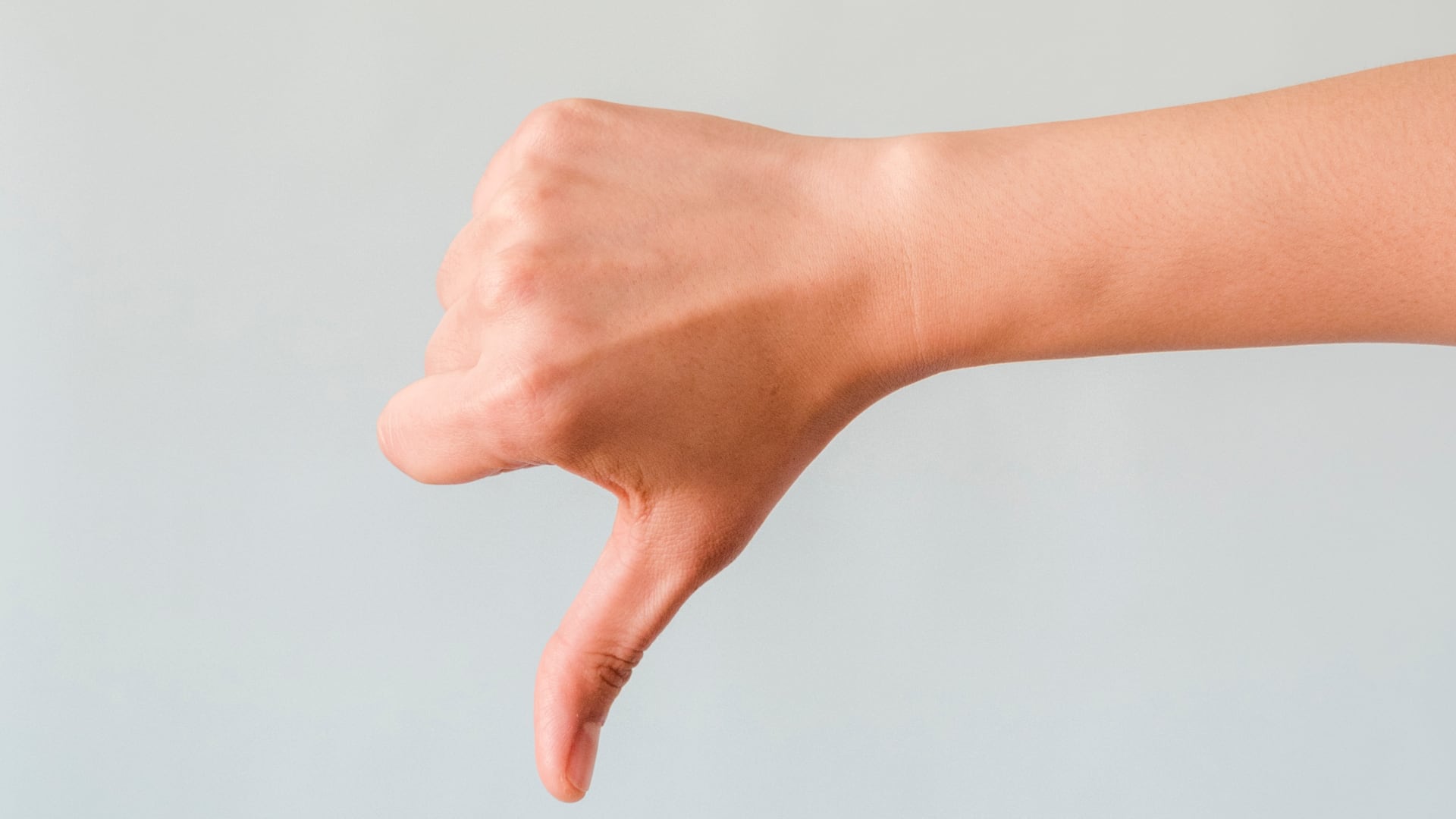 A male hand showing a thumbs-down gesture
