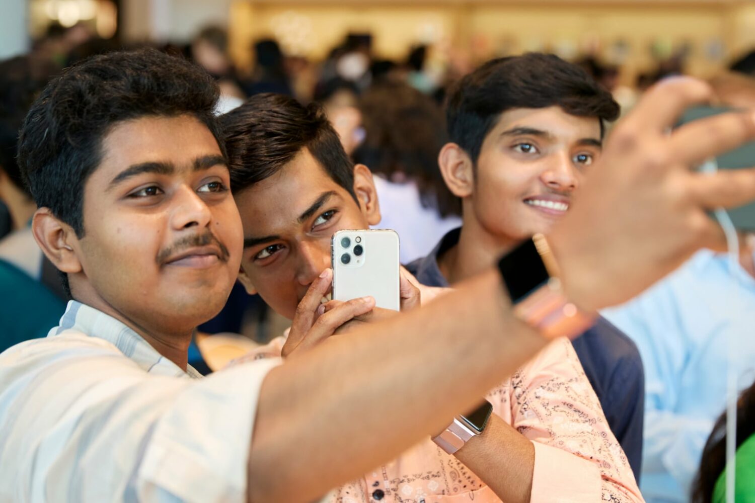 Closeup of there young man taking a selfie with an iPhone at Apple's Mumbai store