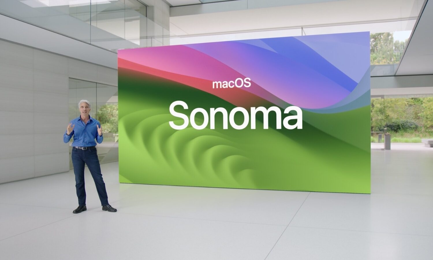 Craig Federighi at WWDC23 standing in front of huge slide showing the macOS Sonoma wallpaper