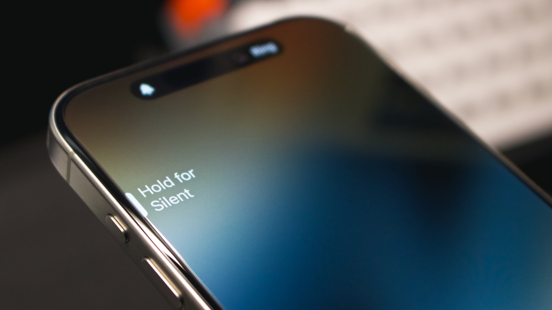 Closeup of the iPhone's Action button with the "Hold for silent" message 