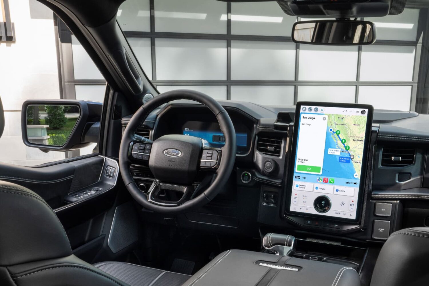 The interior of Ford's F-150 Lightning truck with Apple Maps on CarPlay providing EV routing