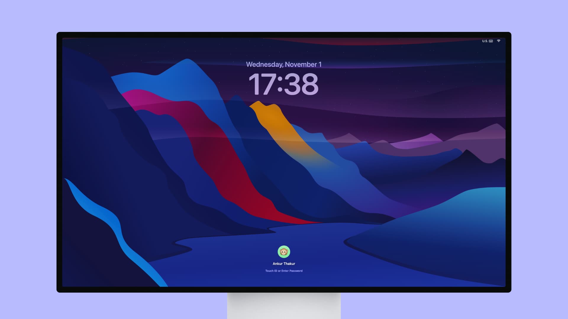 Apple Studio Display showing the macOS Lock Screen with a dark hilly wallpaper