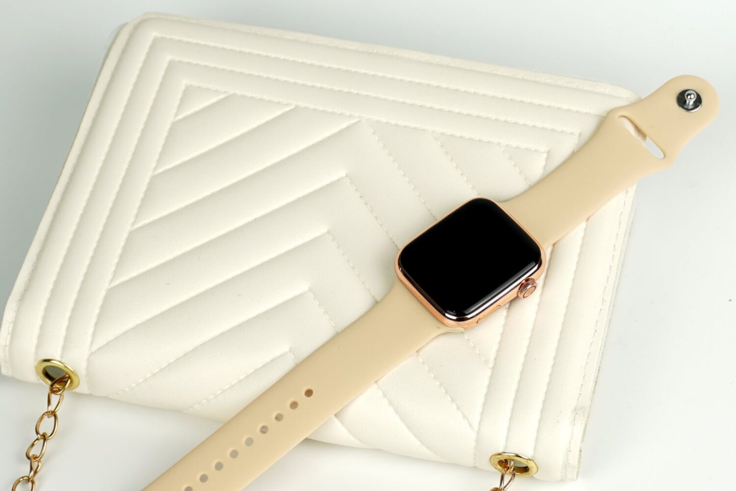 Apple Watch Series 9 with Sport Band on top of a creamy female handbag