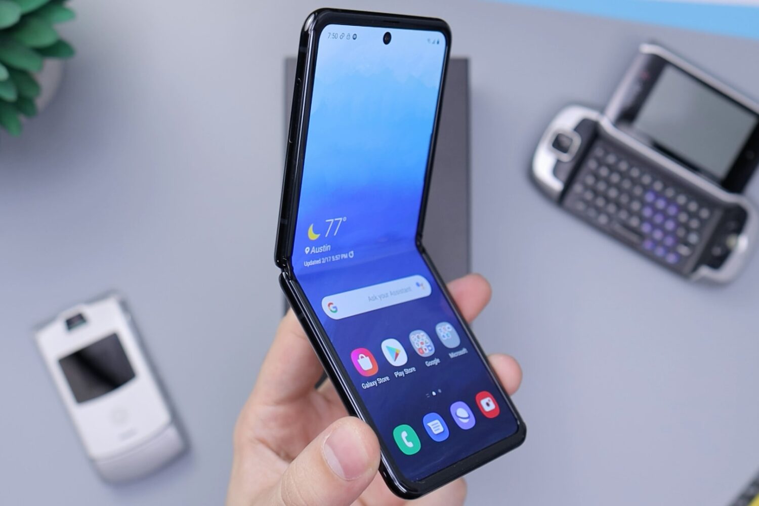 Samsung Galaxy Z Flip in black, half open in a male's palm