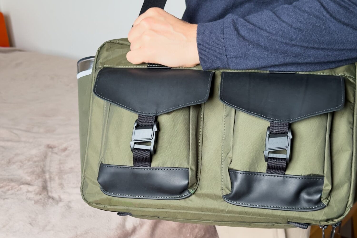 Man carrying Waterfield's X-Air Duffel travel bag on shoulder, showcasing the front pockets