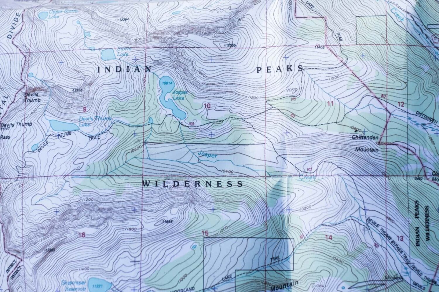 Topographic map of Colorado on paper showcasing contours, hiking trails, hill shades and other natural and man-made terrain features
