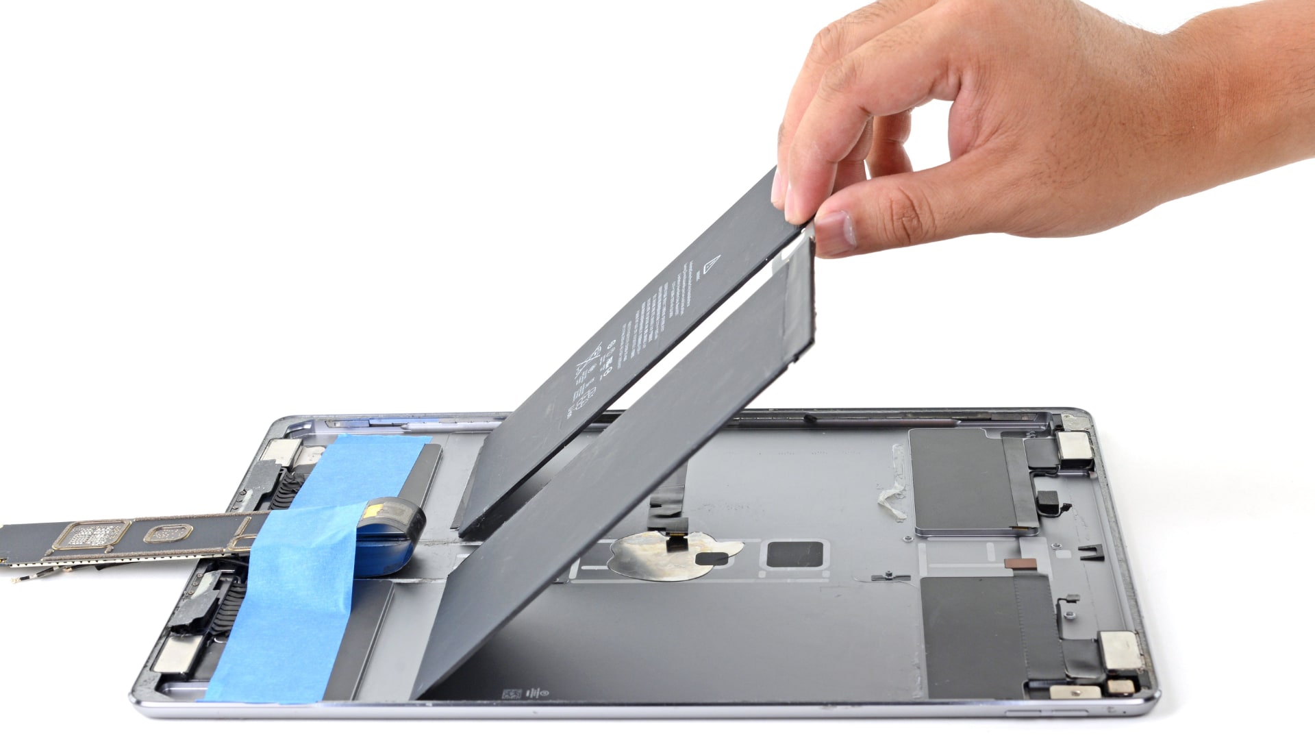 Person's hand taking out a battery from an iPad Pro